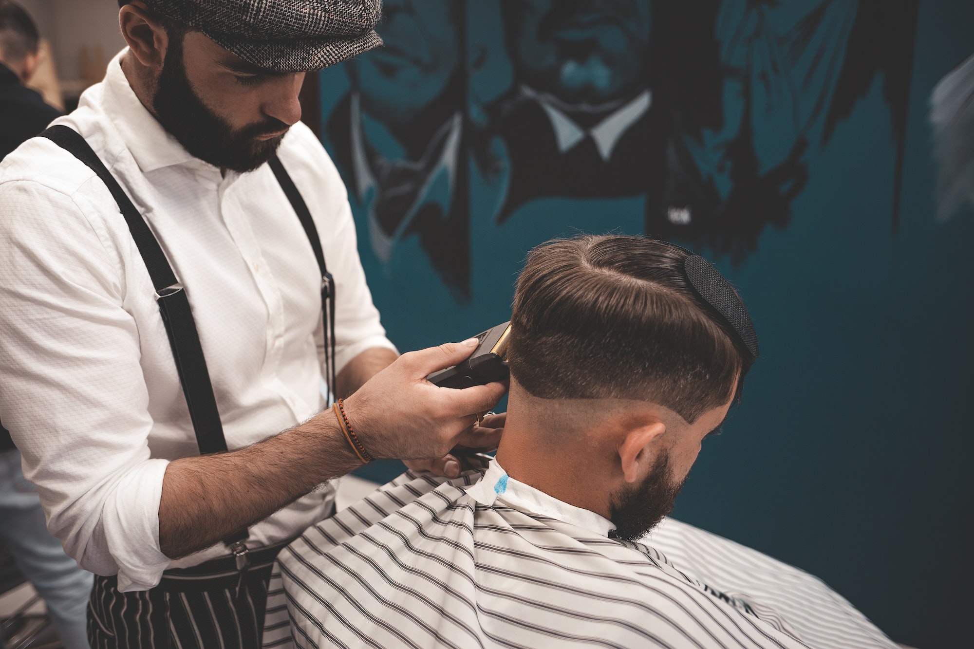 Barber man shaves client in barbershop. Stylish barber makes haircut for guy Barber man shaves client in barbershop. Stylish barber makes haircut for guy