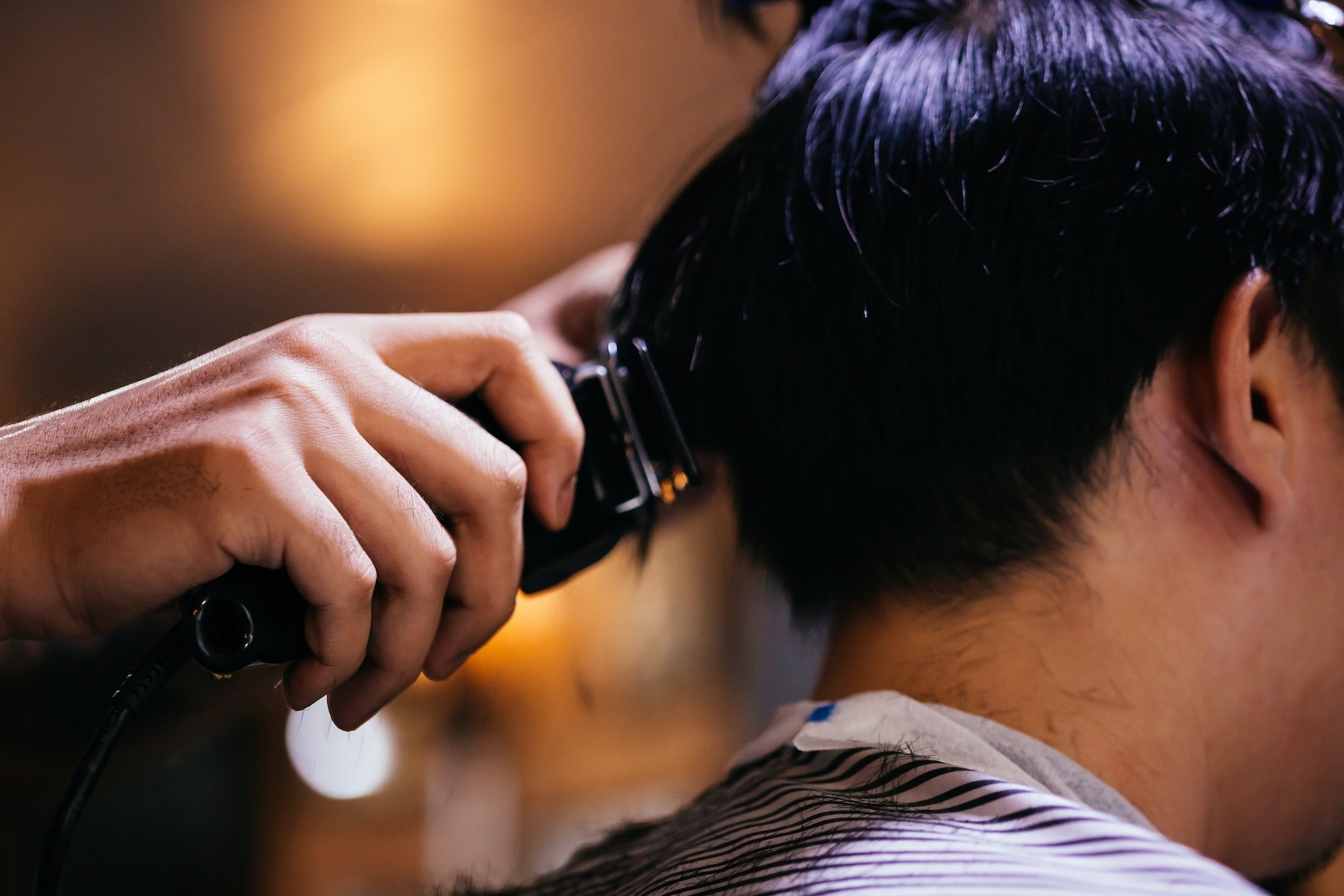 Close up of man's haircut to be trimmed and cut in the barbershop using hair clipper. Close up of man's haircut to be trimmed and cut in the barbershop using hair clipper.