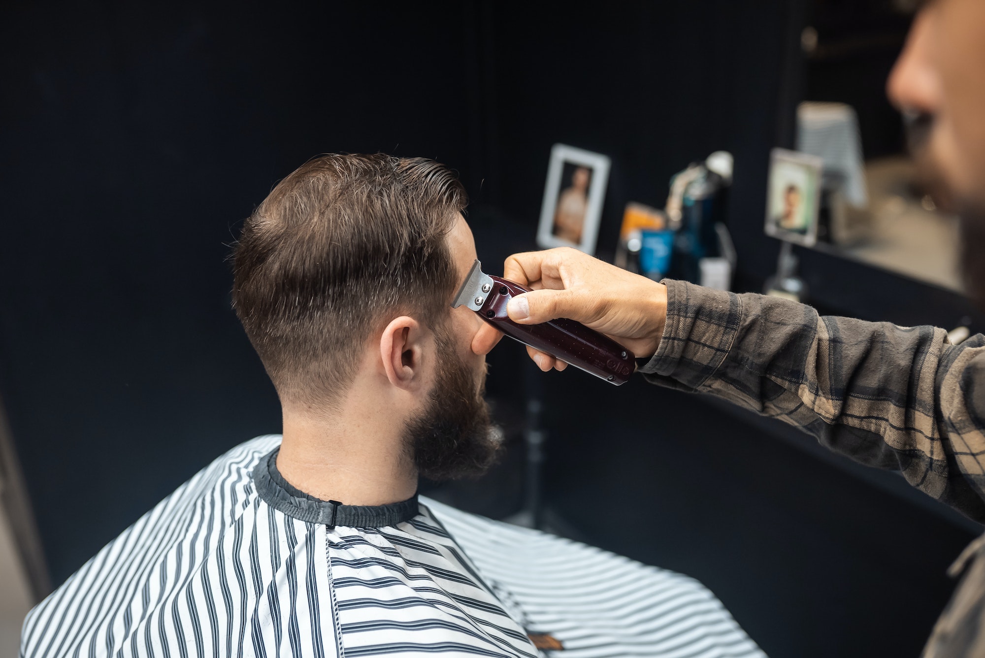 Master in barbershop makes men's haircutting with hair clipper Master in barbershop makes men's haircutting with hair clipper